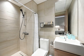 Un bagno moderno con doccia, WC e lavandino.