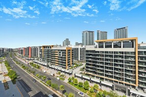 Un moderno edificio a più piani con un'ampia volta centrale, circondato da una strada spaziosa e altri edifici.