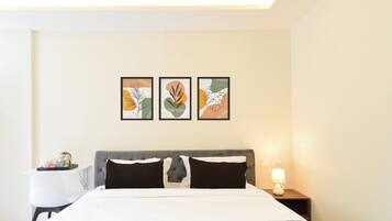 A hotel room with a bed, bedside tables, and wall art.