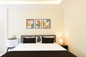Una habitación de hotel con cama, mesitas de noche y decoración en la pared.