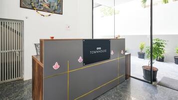 A reception desk with a sign reading 'OYO TOWNHOUSE' and decorative elements.