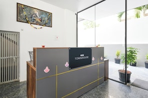 Una recepción con un cartel que dice 'OYO TOWNHOUSE' y elementos decorativos.