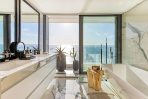 Interior moderno com uma grande janela vista para o mar, design minimalista e piso de mármore elegante.