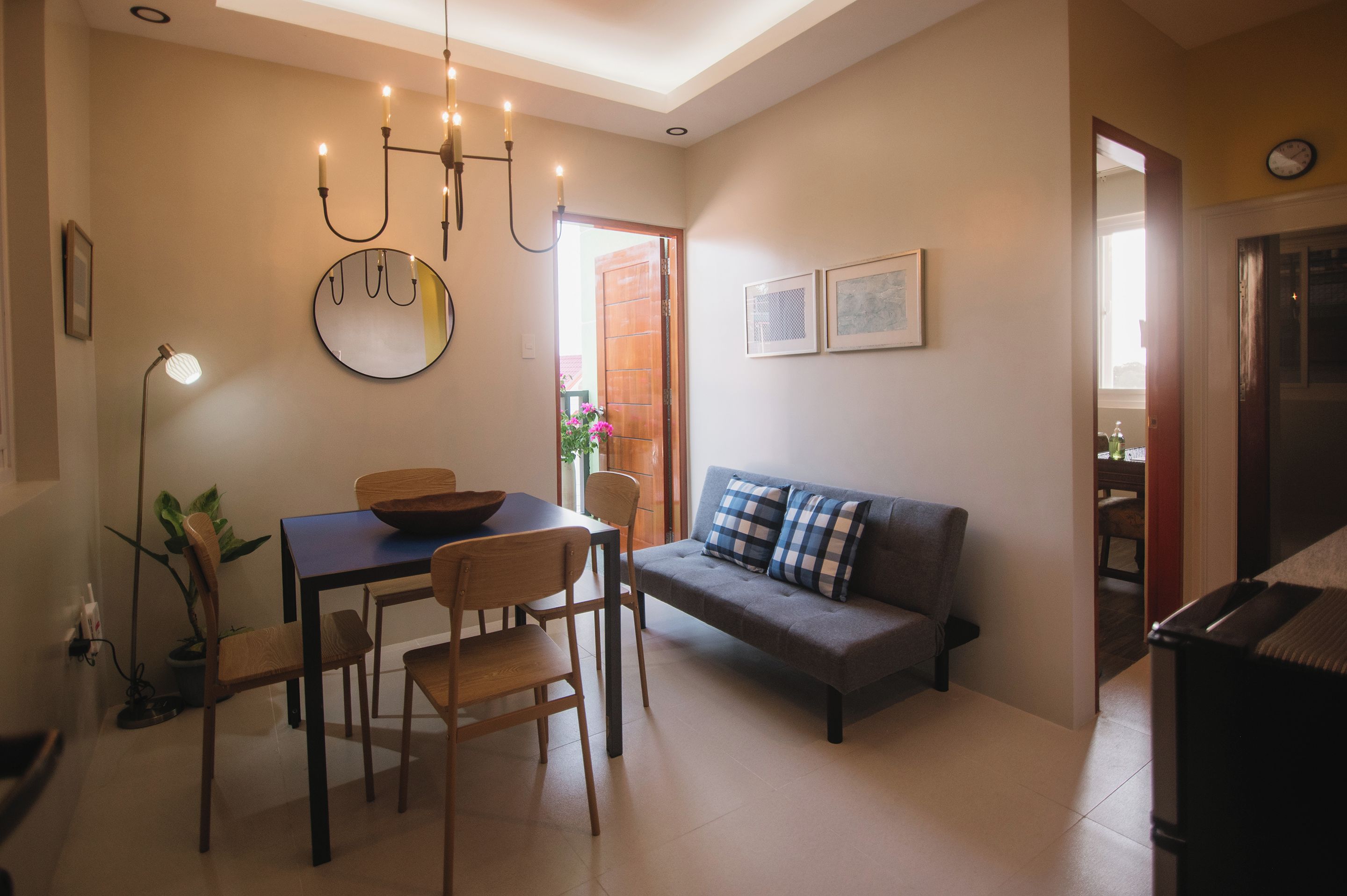 Un comedor con una mesa, sillas, un espejo y un candelabro.