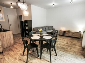 Eine moderne Küche mit Esstisch, Stühlen und einem Kühlschrank.
