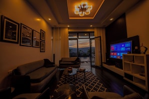 A modern living room with a sofa, coffee table, and a television. - Adorable 4-bedroom house in Kigali perfect for family stays (Kigali)