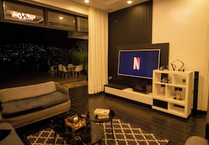 Uma sala de estar moderna com televisão de tela plana, sofá e mesa de centro.