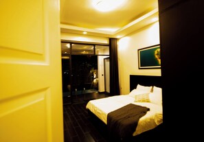 Ein Hotelzimmer mit Bett, einem Bild an der Wand und Blick nach draußen.