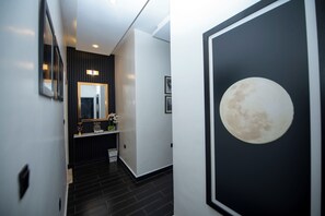 A modern hallway with a black and white color scheme, a large mirror, and a framed picture of the moon. - Adorable 4-bedroom house in Kigali perfect for family stays (Kigali)