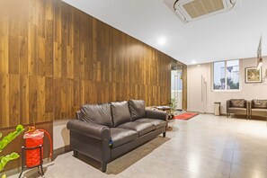 Un interior moderno con un sofá de cuero, paneles de madera y un ventanal grande.