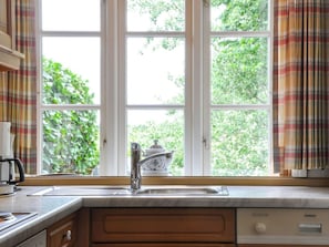 A kitchen with a window, a sink, and a coffee maker. - Karoline House Apartment Jule (Utersum)