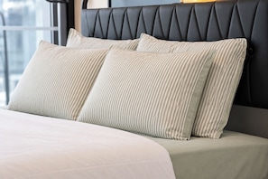 A bed with a headboard, pillows, and a blanket. - Southbank 2BR 2Bath | 2 Queens & Free Parking (Southbank)