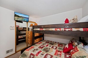 A room with a bunk bed, a television mounted on the wall, a wooden dresser, and a mirror. - Steps from Snow Summit Resort! Ski In/Out Retreat! Incredible Views of Snow Summit Resort! (Big Bear Lake)