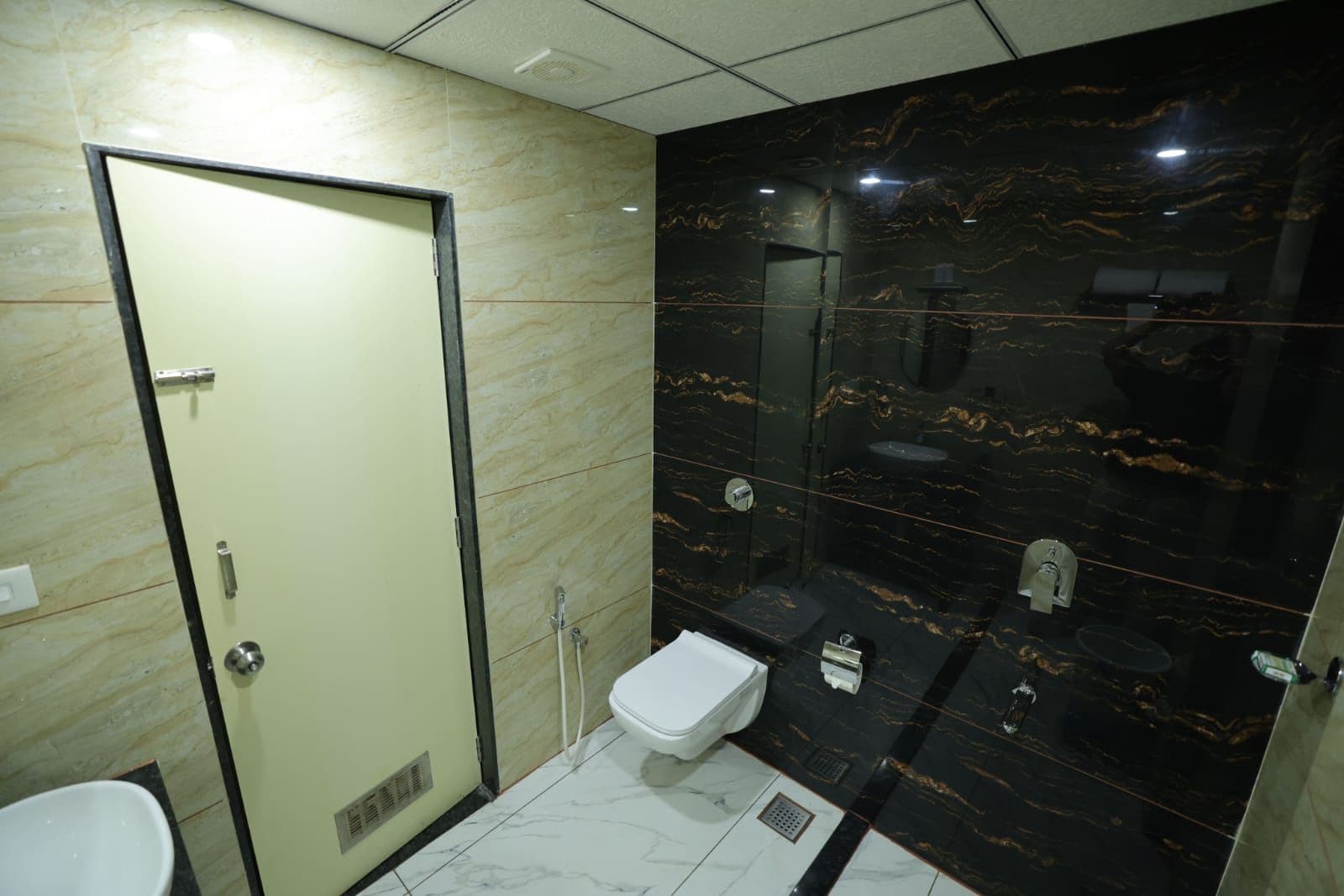 A bathroom with a toilet, a shower, and a sink.