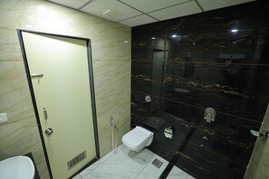 Un baño con inodoro, ducha y lavabo.
