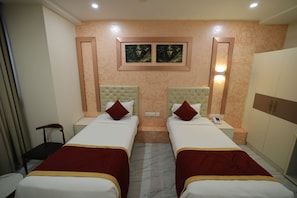 Camera d'albergo con due letti, un armadio, un comodino e una sedia.