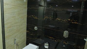 Un bagno con il water bianco, un lavandino e uno spazio doccia.