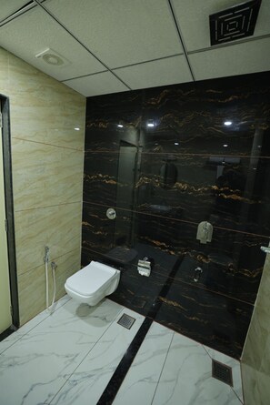 Un bagno con il water bianco, un lavandino e uno spazio doccia.