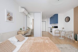 A modern bedroom with a bed, bedside table, and a desk with a chair. - Warsaw | Krochmalna 61 | Modern Studio | Air Conditioning (Warszawa)