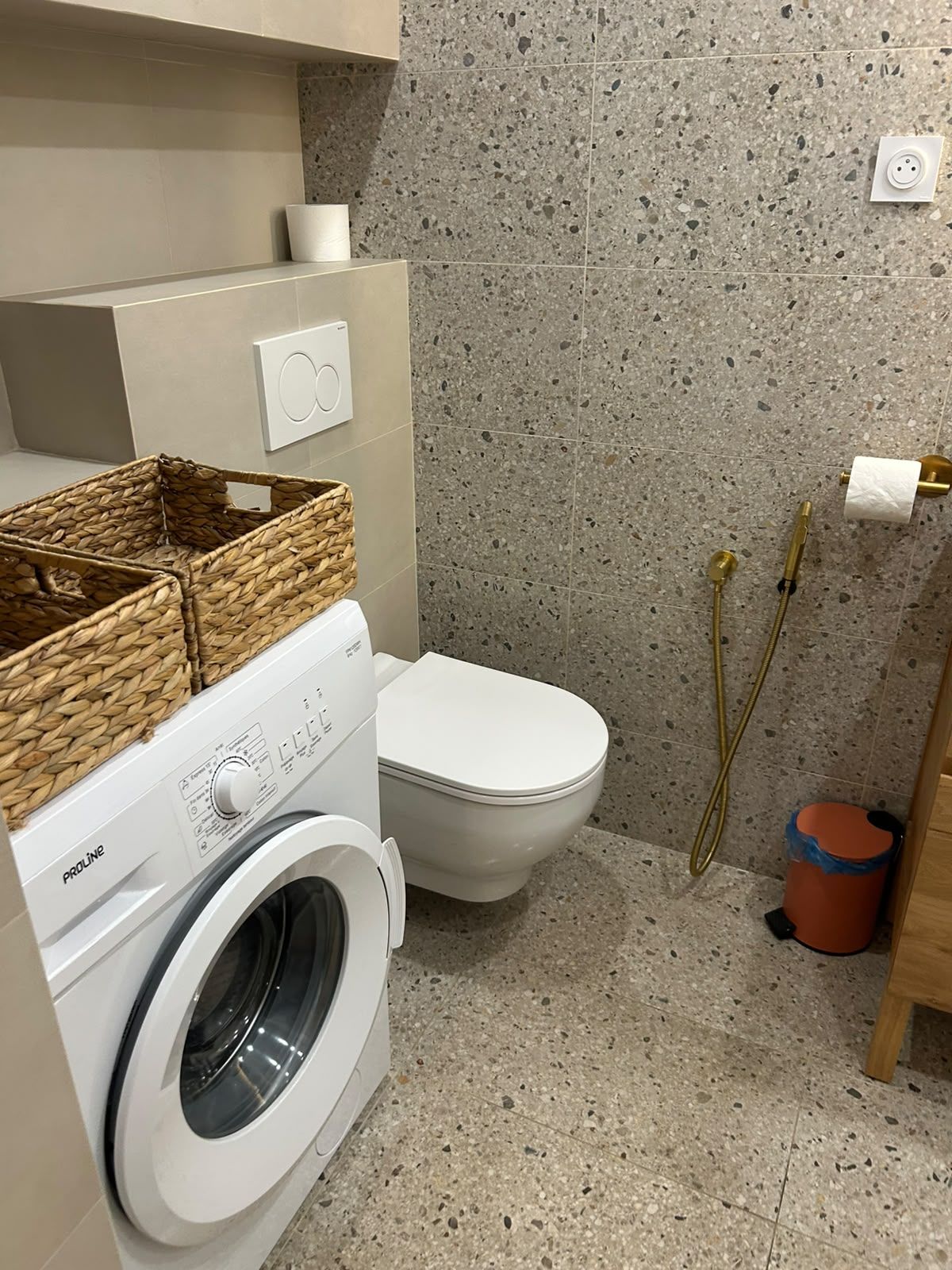 Un bagno piccolo ma funzionale, con lavatrice, WC e zona doccia.