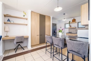 Una cocina moderna con armarios de madera, una barra con taburetes y una mesa de comedor.