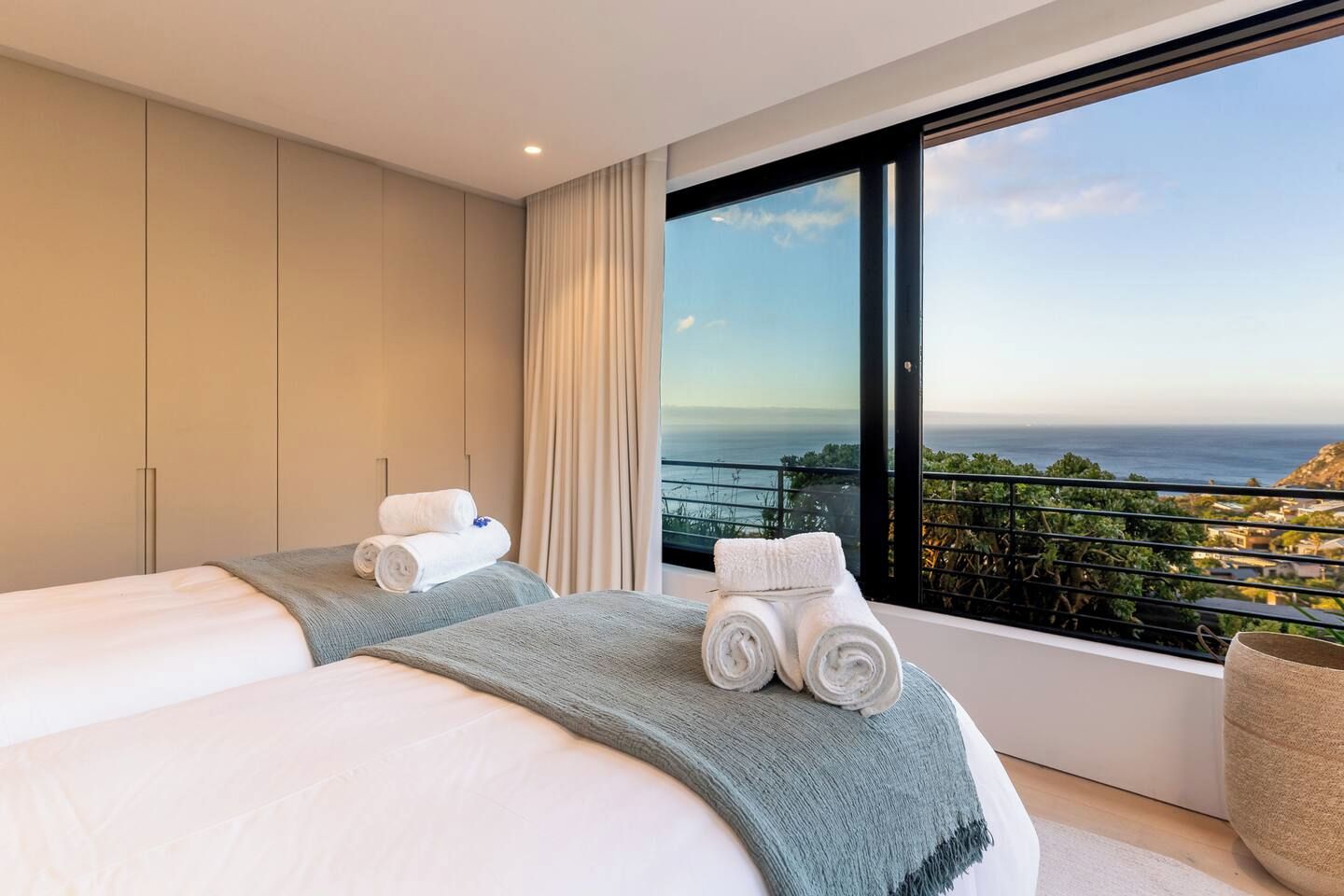 A hotel room with a large bed, a view of the sea, and a balcony.