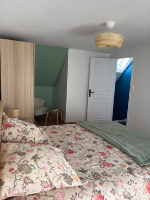 A bedroom with a bed, a chair, a small table, a door, and a window. - ⚓ Charming fisherman's cottage in the heart of Saint-Vaast-la-Hougue (Saint-Vaast-la-Hougue)