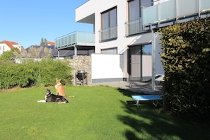 A modern two-story building with a flat roof, a stone wall, and a grassy yard. - Apartment 'Casa Tunix' with Private Pool, Private Terrace and Wi-Fi (Göhren-Lebbin)