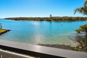 A clear view of a lake with a distant tree-covered island, a dock, and a railing. - Marea by Khove - Kingscliff (Kingscliff)