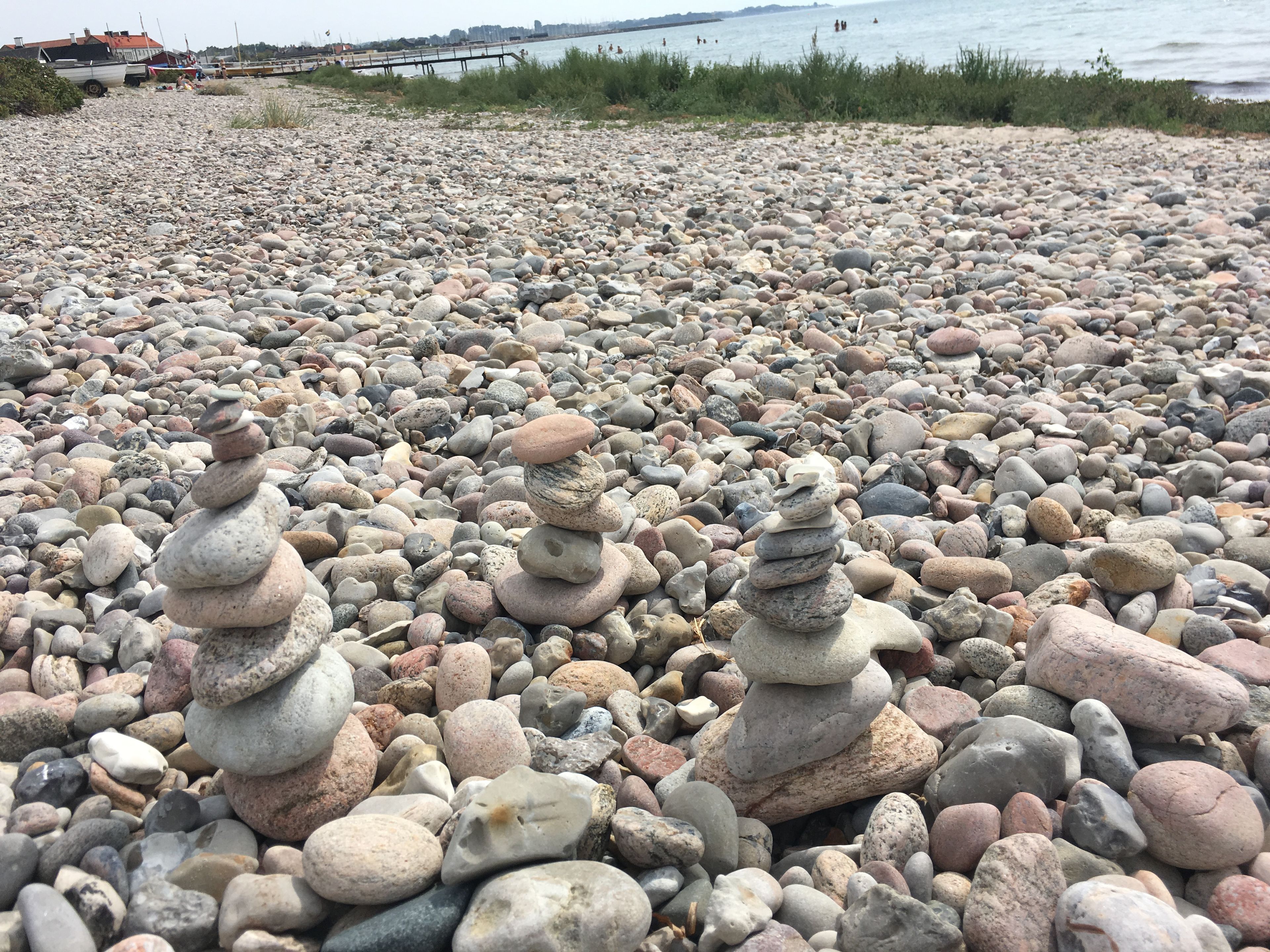 Une plage de galets avec des amas de pierres.