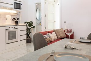 A modern kitchen with a built-in oven, microwave, and a dining area with a table set for two. - Top Floor 2 Bedroom Apartment with Terrace. Next to City of Arts & Oceanografic (València)