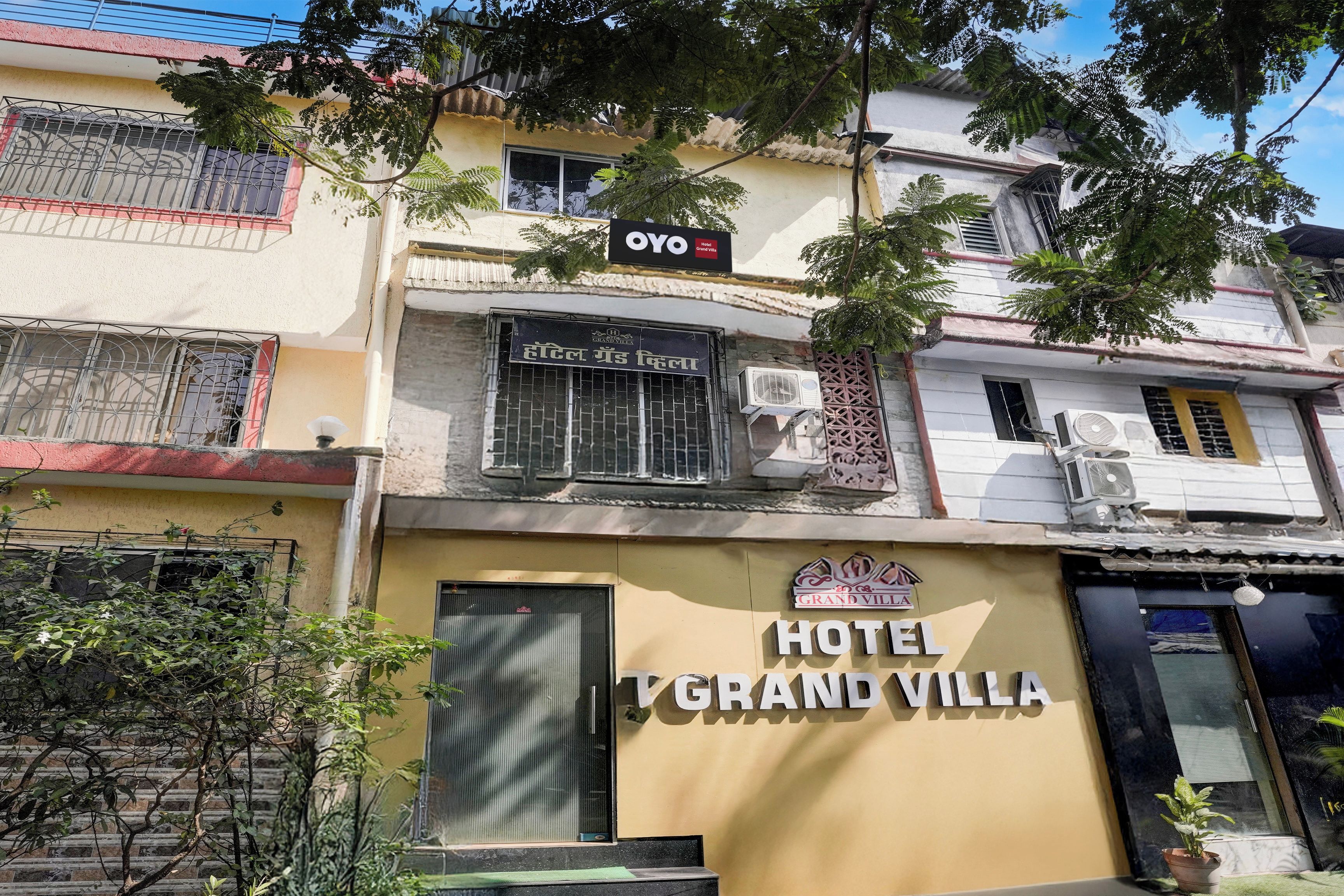 Un edificio con un letrero que dice 'HOTEL GRAND VILLA' y un logotipo de 'GRAND VILLA'.