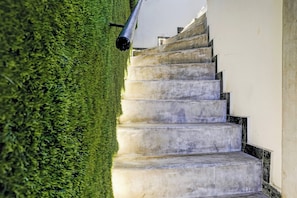 Una escalera de concreto con peldaños y una pared blanca a un lado.