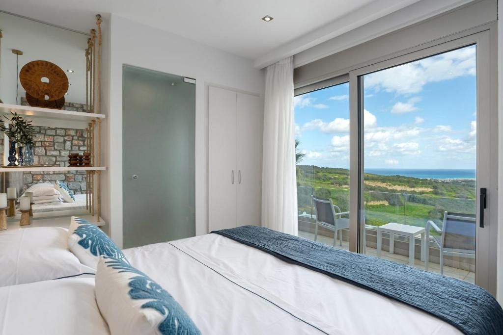 Ein Schlafzimmer mit einem großen Bett, einem Kleiderschrank, einer Ablage mit Dekoration und einem Balkon mit Blick auf die Landschaft.