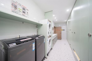 A hotel bathroom with a washing machine, dryer, and a sink. - Litchi in Red - outh Stay Inn (Guangzhou)