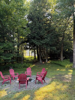 A forested area with a seating arrangement of five Adirondack chairs. - NEW TASTEFULLY UPDATED RUSTIC CAMP WATERFRONT! IN OLD FORGE (Old Forge)