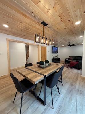 A dining area with a wooden table, black chairs, and a ceiling fan. - NEW TASTEFULLY UPDATED RUSTIC CAMP WATERFRONT! IN OLD FORGE (Old Forge)