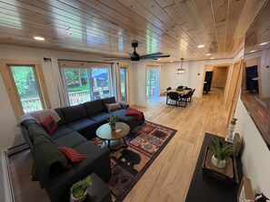 A spacious living area with a sectional sofa, a coffee table, and a dining table with chairs. - NEW TASTEFULLY UPDATED RUSTIC CAMP WATERFRONT! IN OLD FORGE (Old Forge)