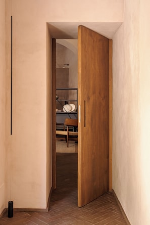 A narrow hallway with a wooden door leading to a bedroom. - Serra Novecento Garden Suite & Residence _La Veranda_ (Bellano)
