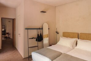 A hotel room with a bed, a wardrobe, a mirror, and a bedside table. - Serra Novecento Garden Suite & Residence _La Veranda_ (Bellano)