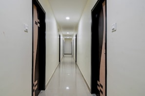 A long, narrow hallway with doors on both sides, leading to individual rooms. - Hotel O SS INN (Bhubaneshwar)