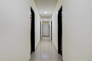 A long, narrow hallway with doors on both sides, leading to rooms.