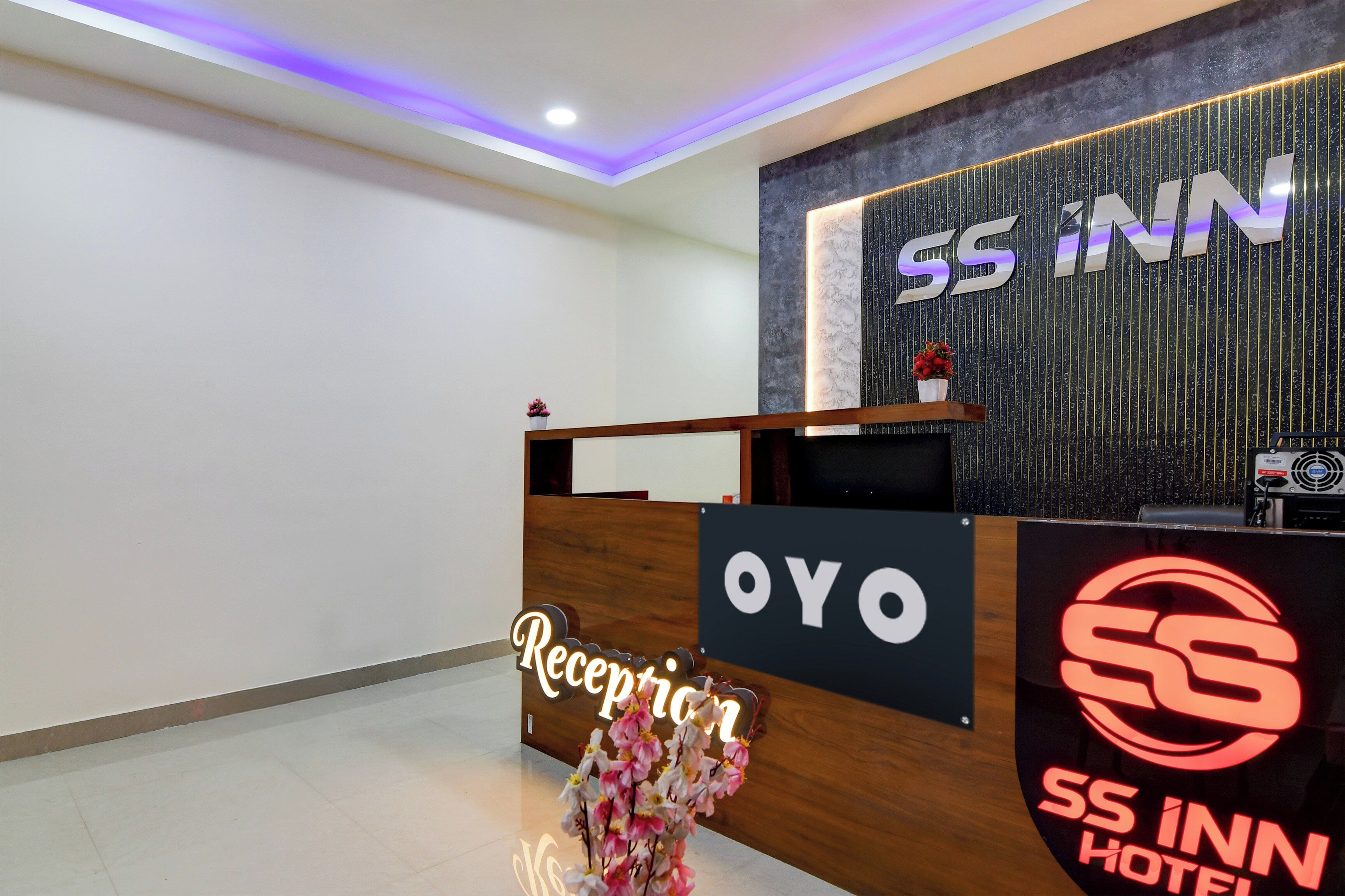 A hotel reception desk with a sign that reads 'SS INN HOTEL'.