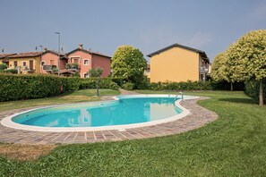 A residential area with a swimming pool, houses, and well-maintained lawns. - Apartment 'Casa Vacanze Da Ricky App 6' with Shared Pool, Wi-Fi and Air Conditioning (Peschiera del Garda)
