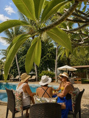 A poolside area with lounge chairs and umbrellas, surrounded by palm trees. - Bazaar Square Lodges - Jasmin (Grand Baie)