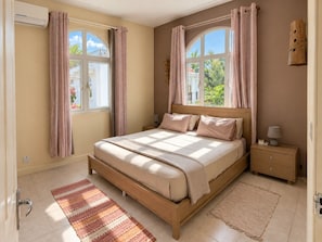 A bedroom with a bed, nightstands, a window, and curtains. - Bazaar Square Lodges - Jasmin (Grand Baie)