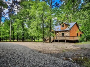 Eine Holzhütte mit Steinfundament und einer Veranda mit Geländer.