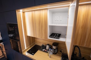 A compact kitchenette with a microwave, coffee maker, and a small countertop. - Luxury 1BR  Self Entry Near
KAFD Riyadh Blvd (Riyadh)