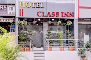 A hotel named 'CLASS INN' with a modern facade, large windows, and potted plants at the entrance. - Hotel O Class Inn (Mumbai)