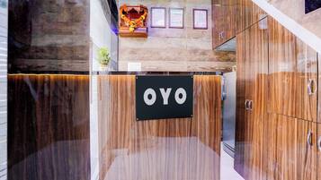 A reception area with a sign that reads 'OYO' and a wall-mounted display case with certificates.